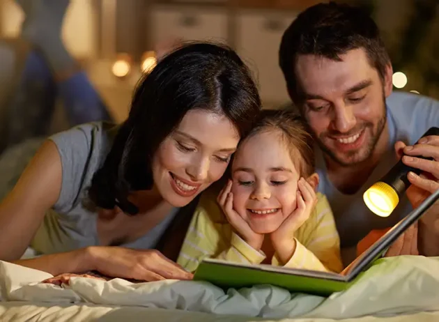 comfortable mother and father reading a bed time story with their daughter while enjoying the comfort of their home o'fallon il