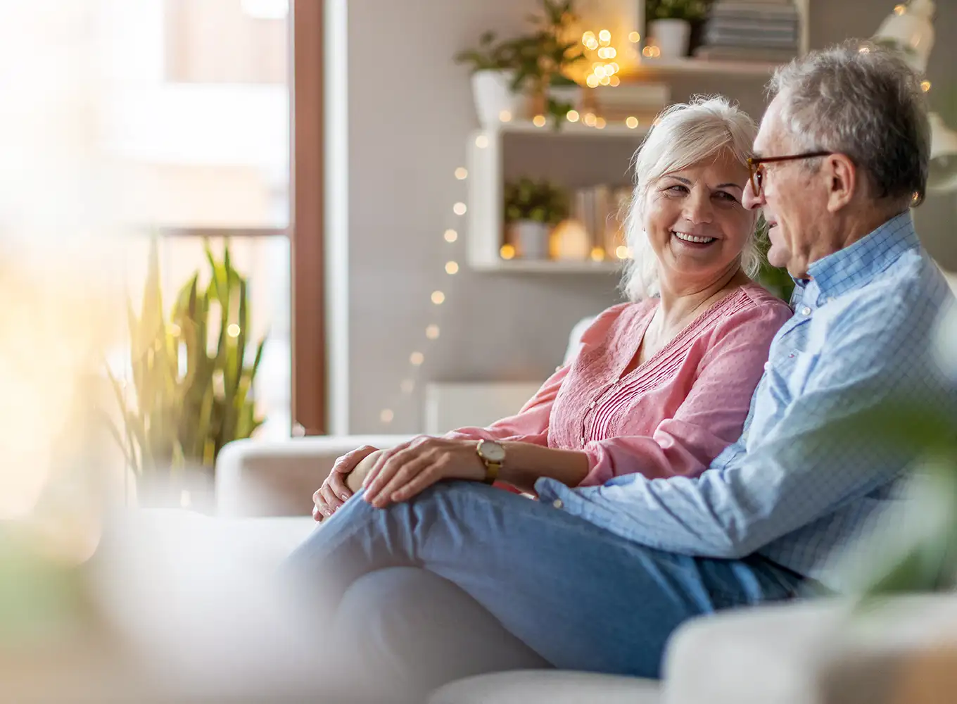 happy elderly couple sitting comfortably in their home