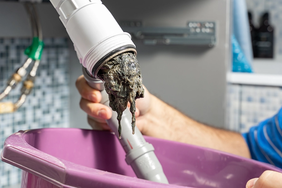 Plumber clearing clog from pipes of a drain in an O’Fallon, IL home.