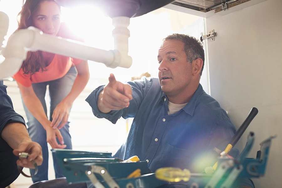 Plumber working on pipes showing O’Fallon, IL, homeowner what the issue is that is causing water hammer.