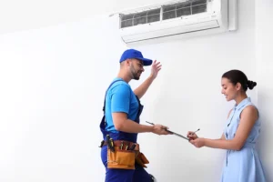 A professional HVAC technician helps a female homeowner sign up for a home maintenance plan for her systems in Collinsville, IL.