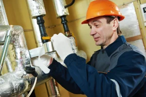 A professional technician insulating the pipes of a heating system in a Collinsville, IL home.