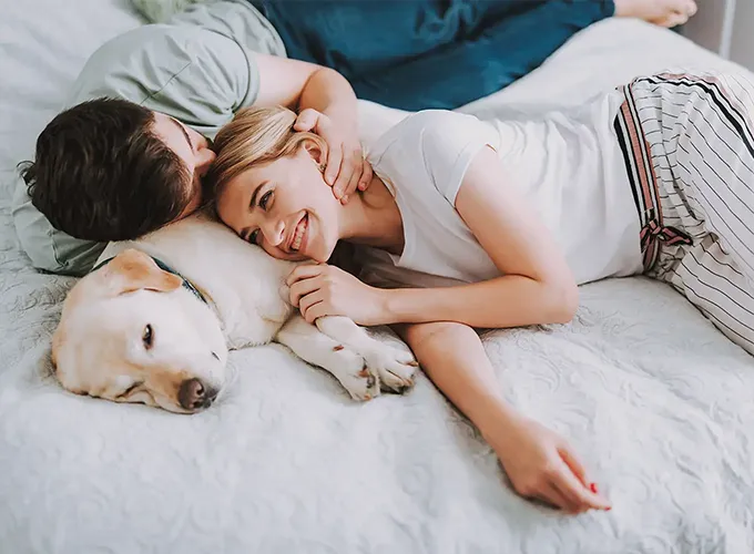 a couple and their Labrador Retriever cozy in their bed while enjoying their heated home collinsville illinois