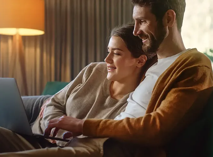 cozy couple on couch while on laptop