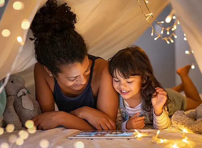 mother and daughter lying comfortably under an indoor tent