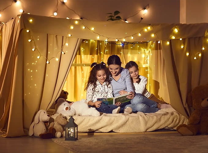 family reading a story book in the comfort of their home