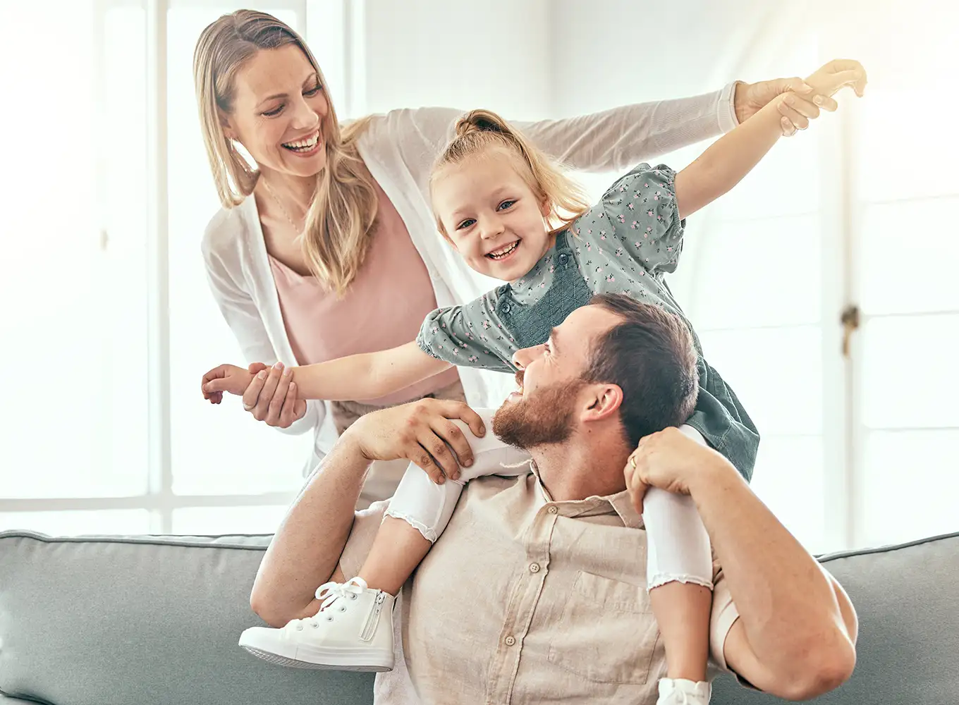 father and mother playing with their daughter