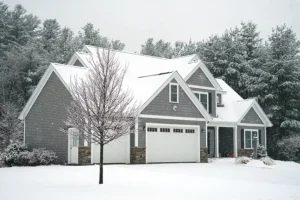 A home in Belleville IL covered with snow indicating that homeowners need to follow a winter plumbing checklist to keep their plumbing protected.