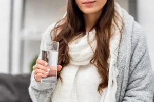 A woman in O'Fallon IL drinking clean, purified water after filtration upgrade.