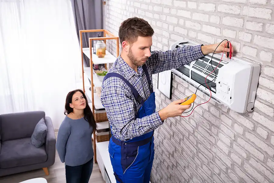 Polar—A male technician examines a home air conditioner to see if it needs repairs in an O’Fallon, IL home.