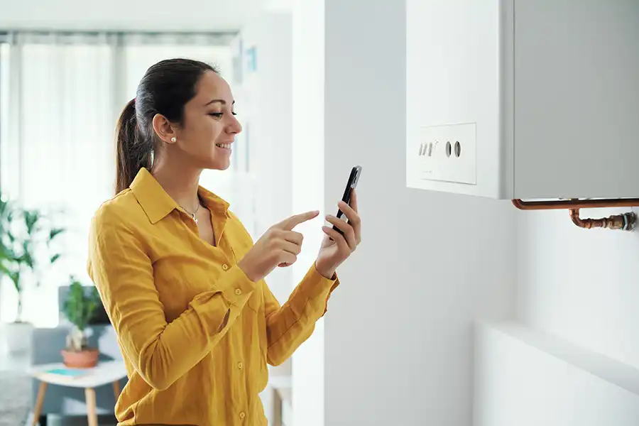 Polar—A young female homeowner manages her smart boiler with her phone in her O’Fallon, IL home.