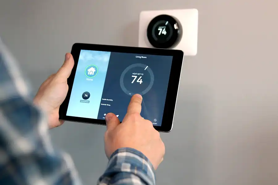 Polar—A man adjusts a temperature using a tablet with a smart home app in a modern living room in Belleville, IL.