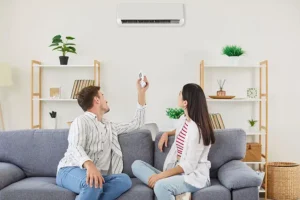 POLAR—A young couple turning on air conditioner while sitting on sofa in living room in O’Fallon, IL.