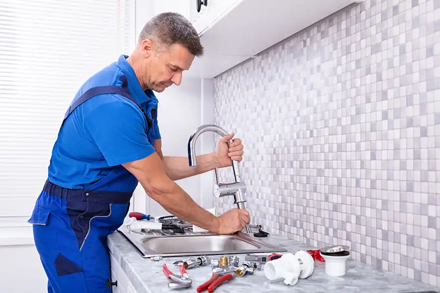 Polar—A plumber works on the kitchen sink to improve the plumbing system in a home in Collinsville, IL.